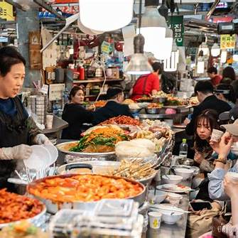 Korea Food Travel Guide 2025 Gwangjang Market street food stalls with locals eating tteokbokki and pancakes