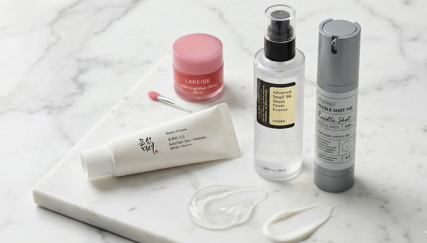 Essential K-beauty products 2026 for the Australian market, featuring Beauty of Joseon Sunscreen, COSRX Snail Mucin, VT Reedle Shot, and Laneige Lip Mask on a marble background