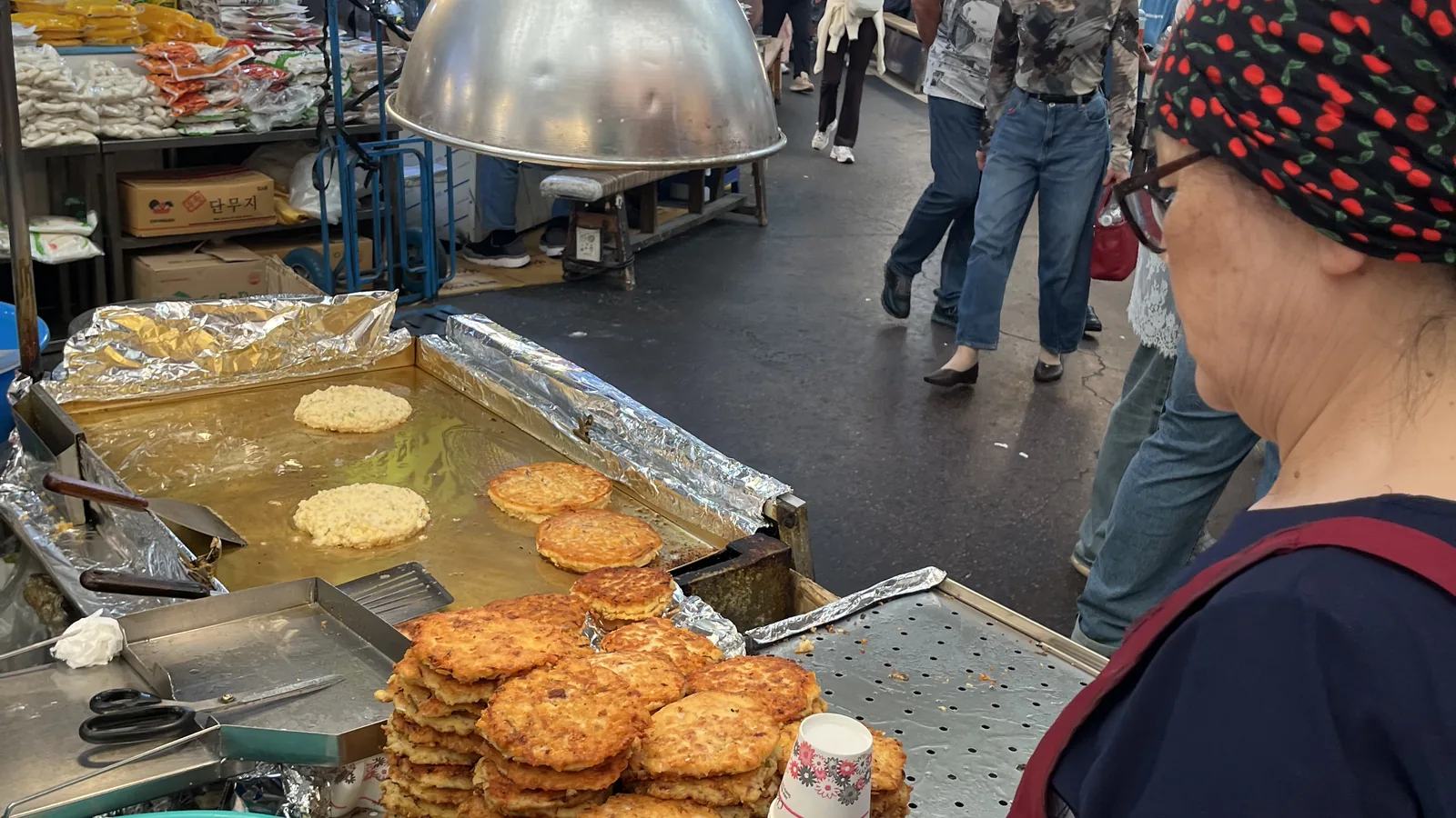 Gwangjang Market bindaetteok frying in shallow pans at a market stall