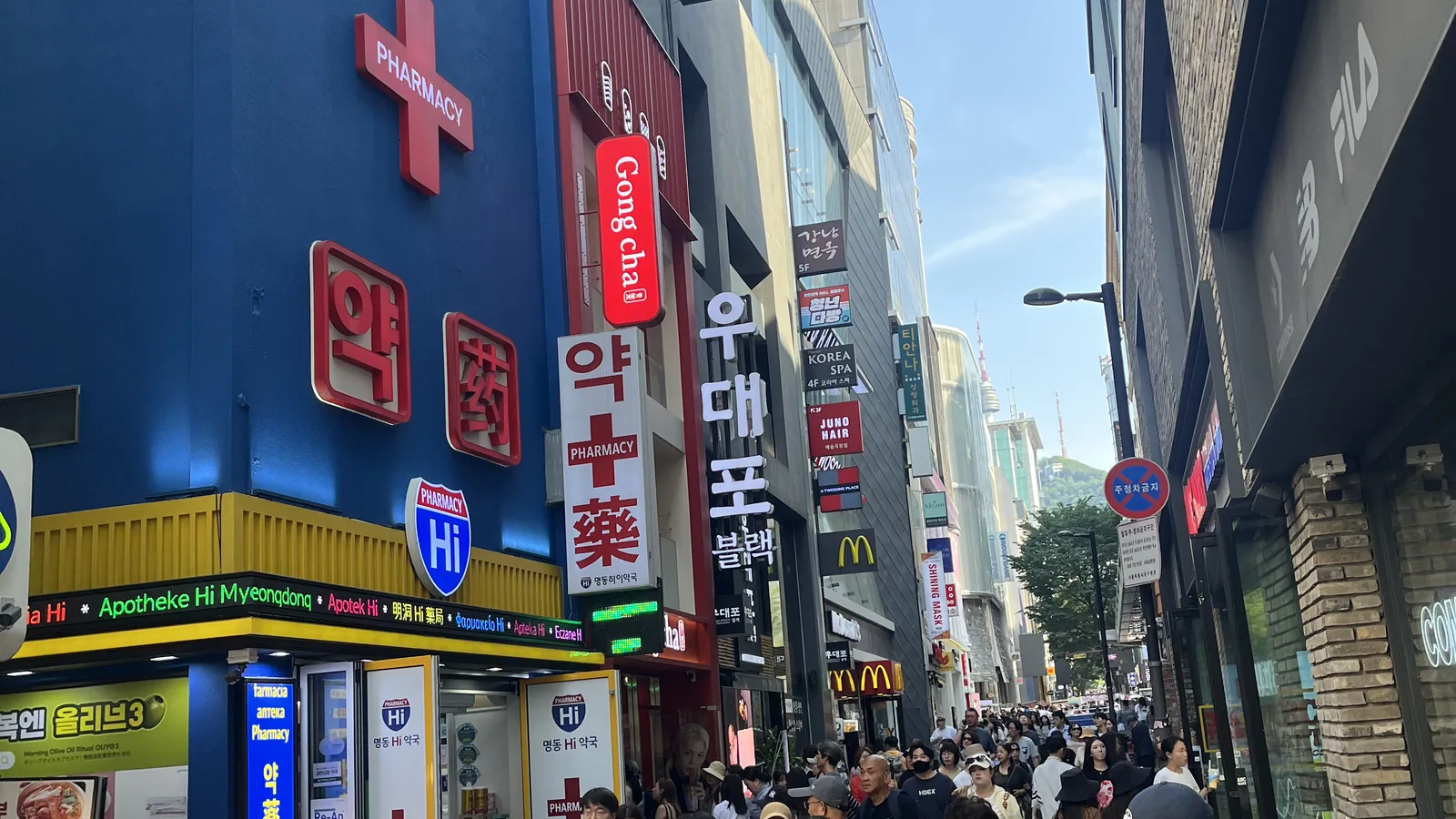 Myeongdong travel guide view of the busy main shopping street packed with crowds on a clear day