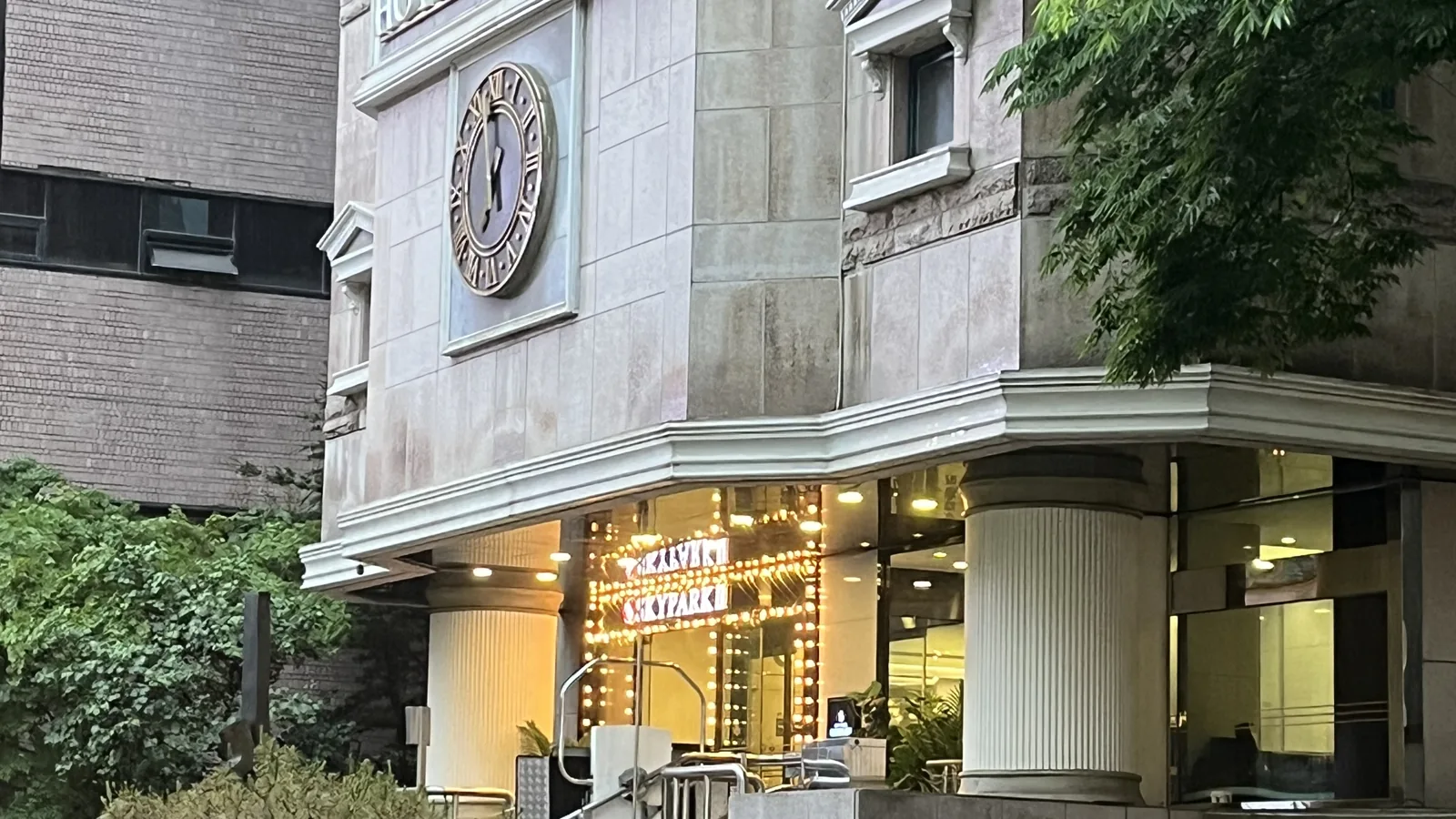 Classic stone hotel facade lit at night showing where to stay in Myeongdong