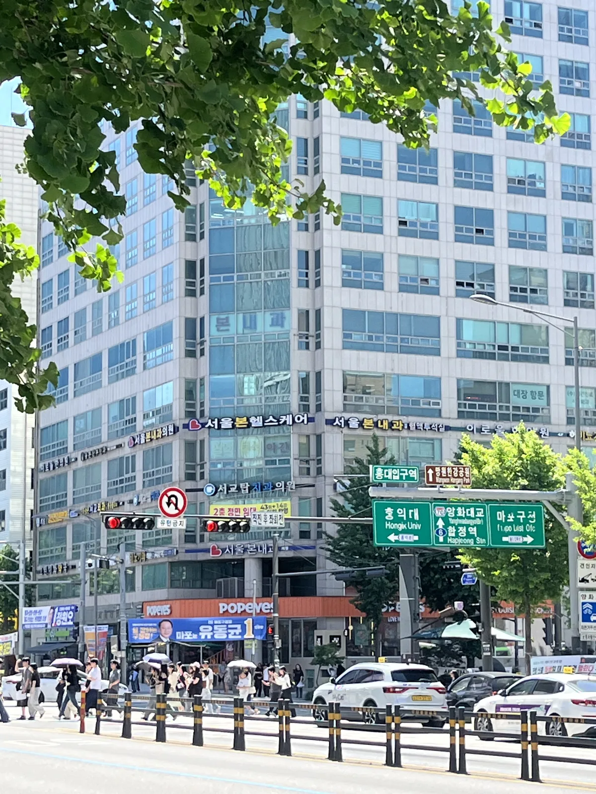 Hongik University Station intersection with green Hongik Univ direction signs in Hongdae