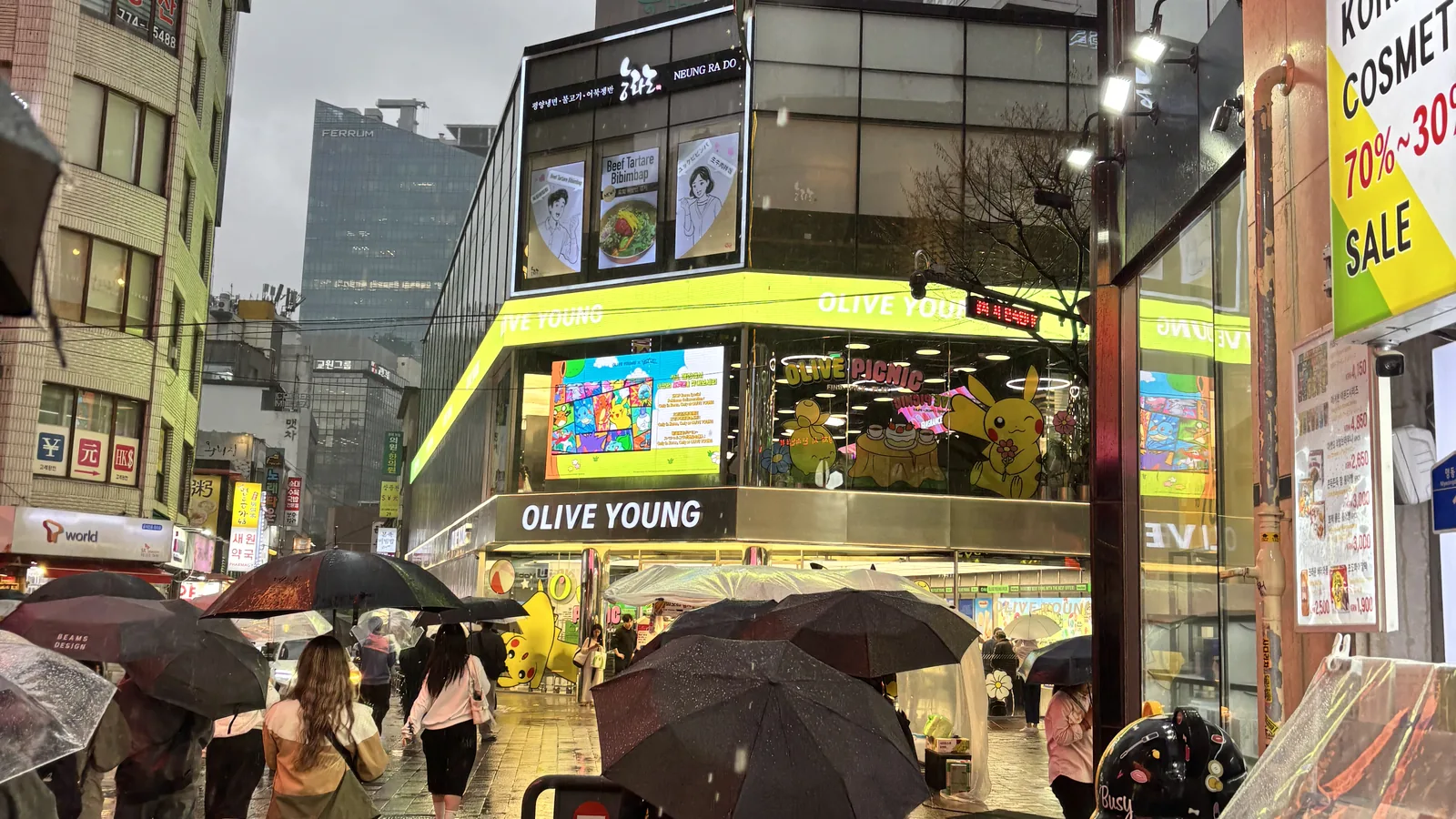 Myeongdong cosmetics shopping at the Olive Young flagship with Pokemon displays and a sale sign