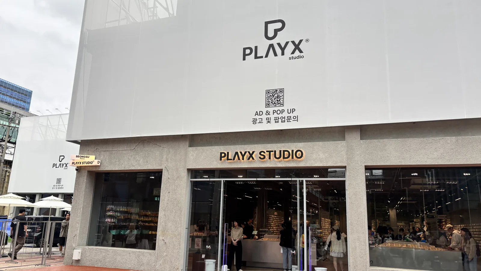 Seongsu pop-up stores entrance at PLAYX Studio with visitors lining up on red brick