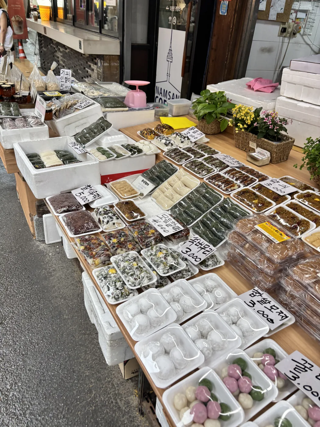 What to buy at Namdaemun Market shown by trays of fresh Korean rice cakes at a tteok stall