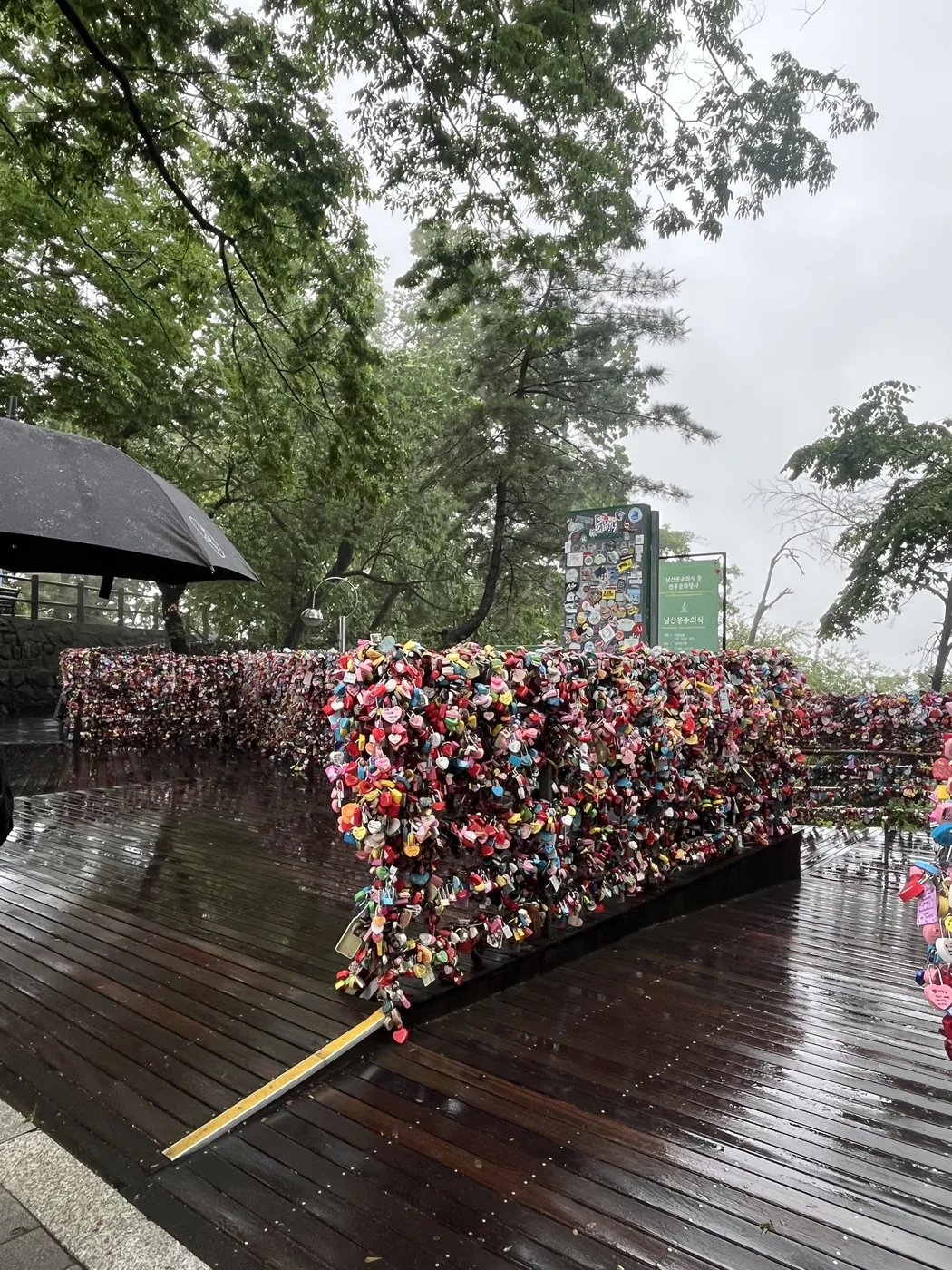 Namsan love locks covering a railing tunnel on a rainy terrace