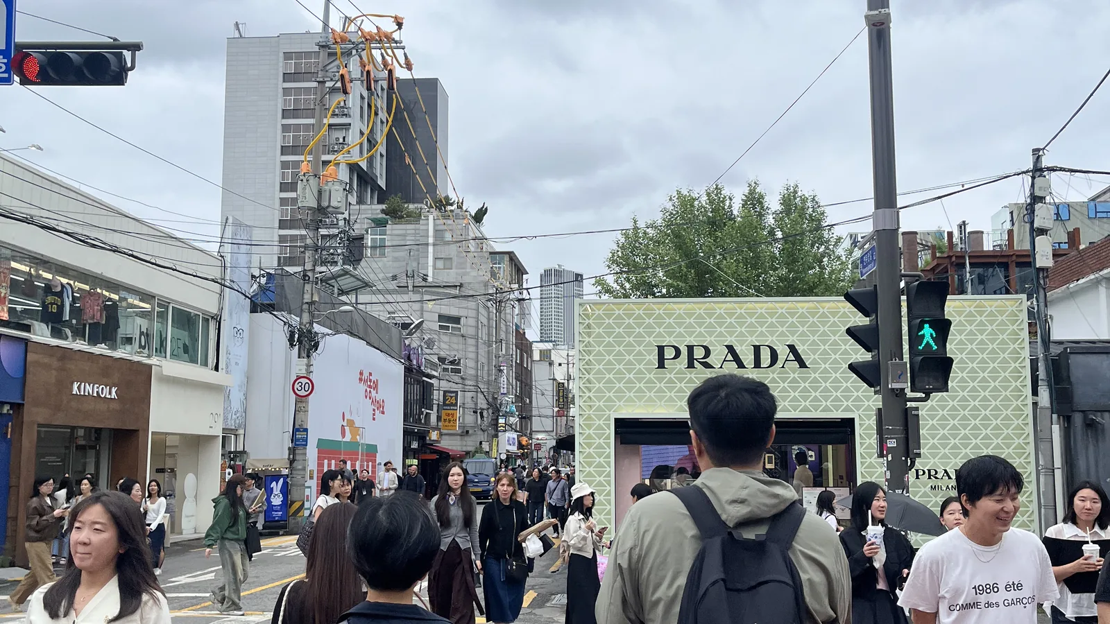 Seongsu-dong shopping guide scene at the Prada pop-up with a crowd waiting at the crossing