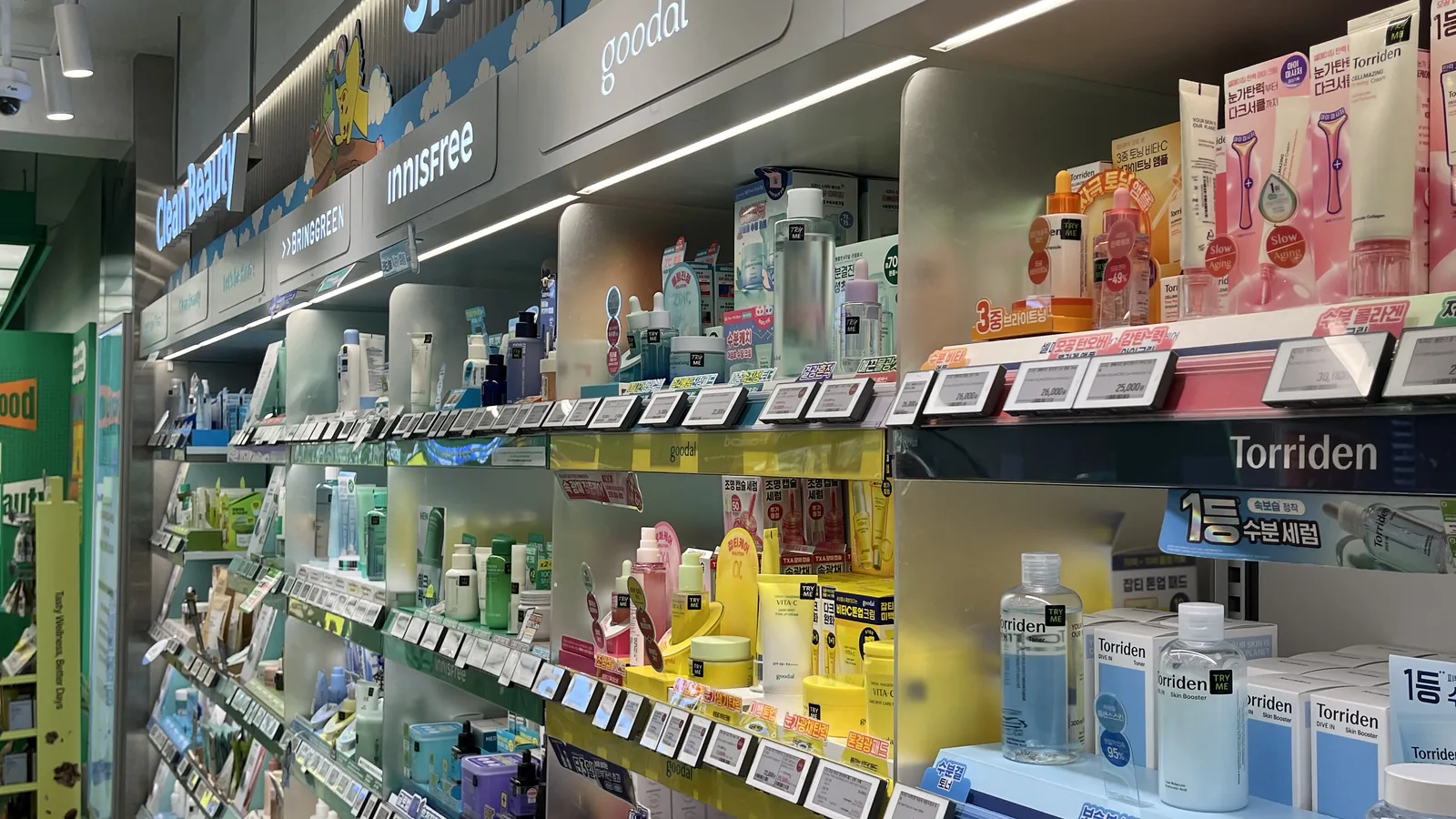 Olive Young toners and essences lined up on a store shelf with brightly coloured bottles