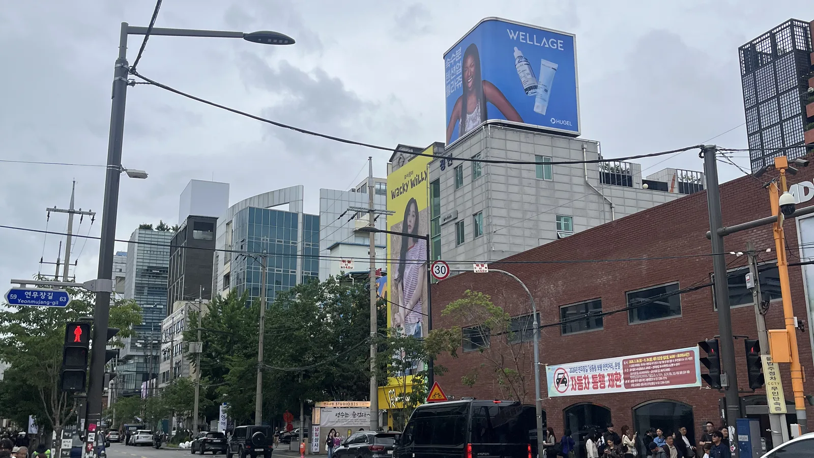 Korean skincare shops in Seongsu street view with the WELLAGE rooftop billboard above the road