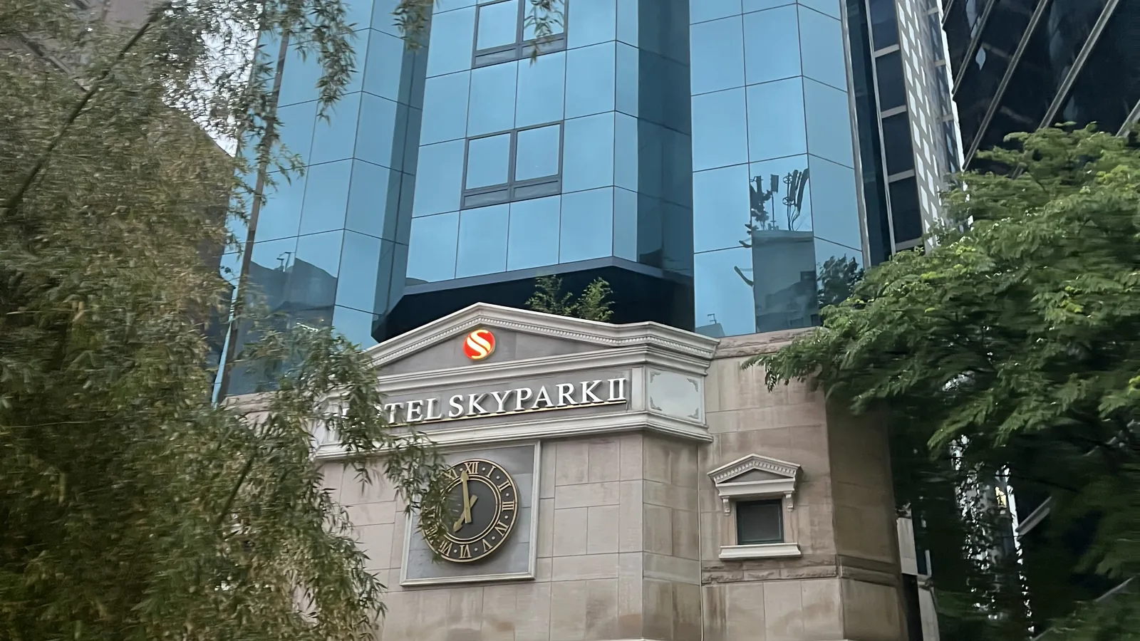 Leafy Myeongdong hotel street by day showing where to stay in Myeongdong