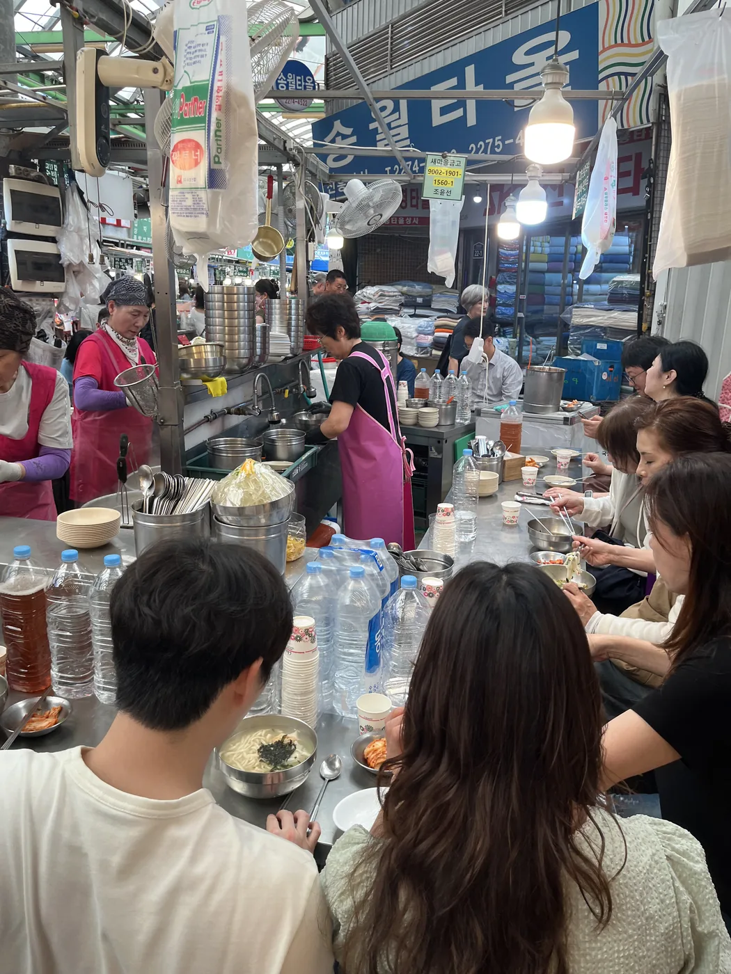 Gwangjang Market food guide view of people eating together at a market counter
