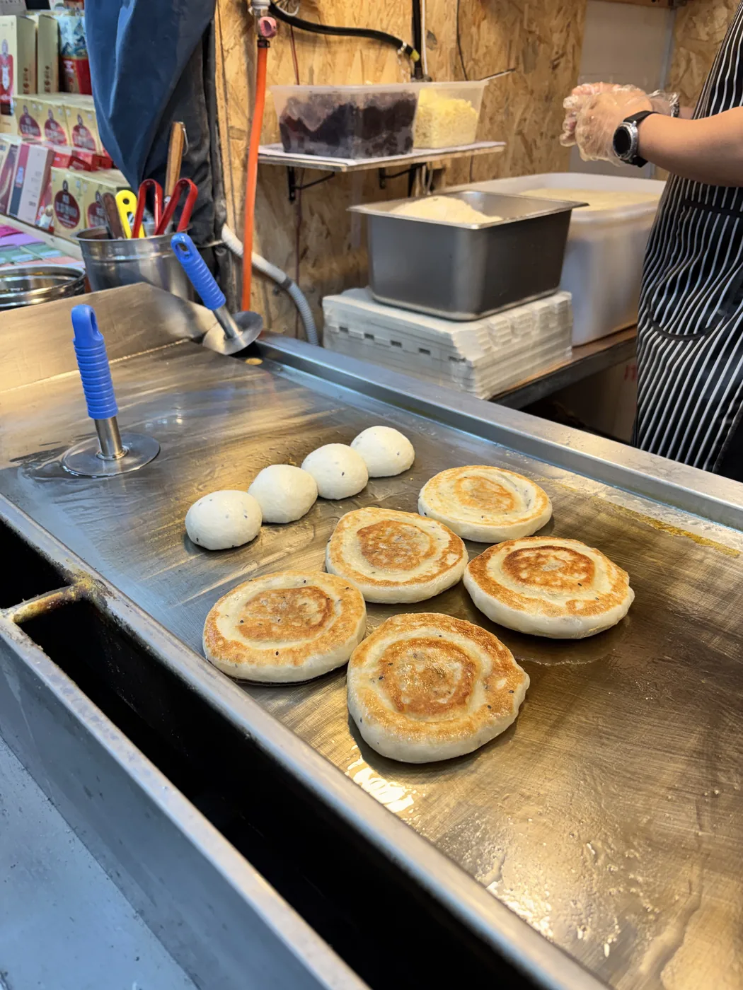 Namdaemun Market street food shown by a vendor frying pancakes on a griddle