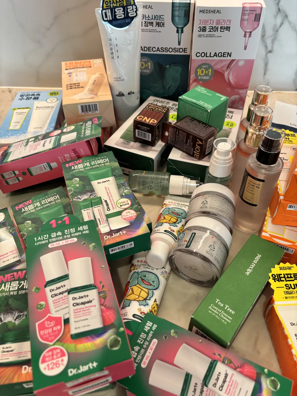 Olive Young haul flat-lay including the Dr.Jart Teatreement Spot and other K-beauty products
