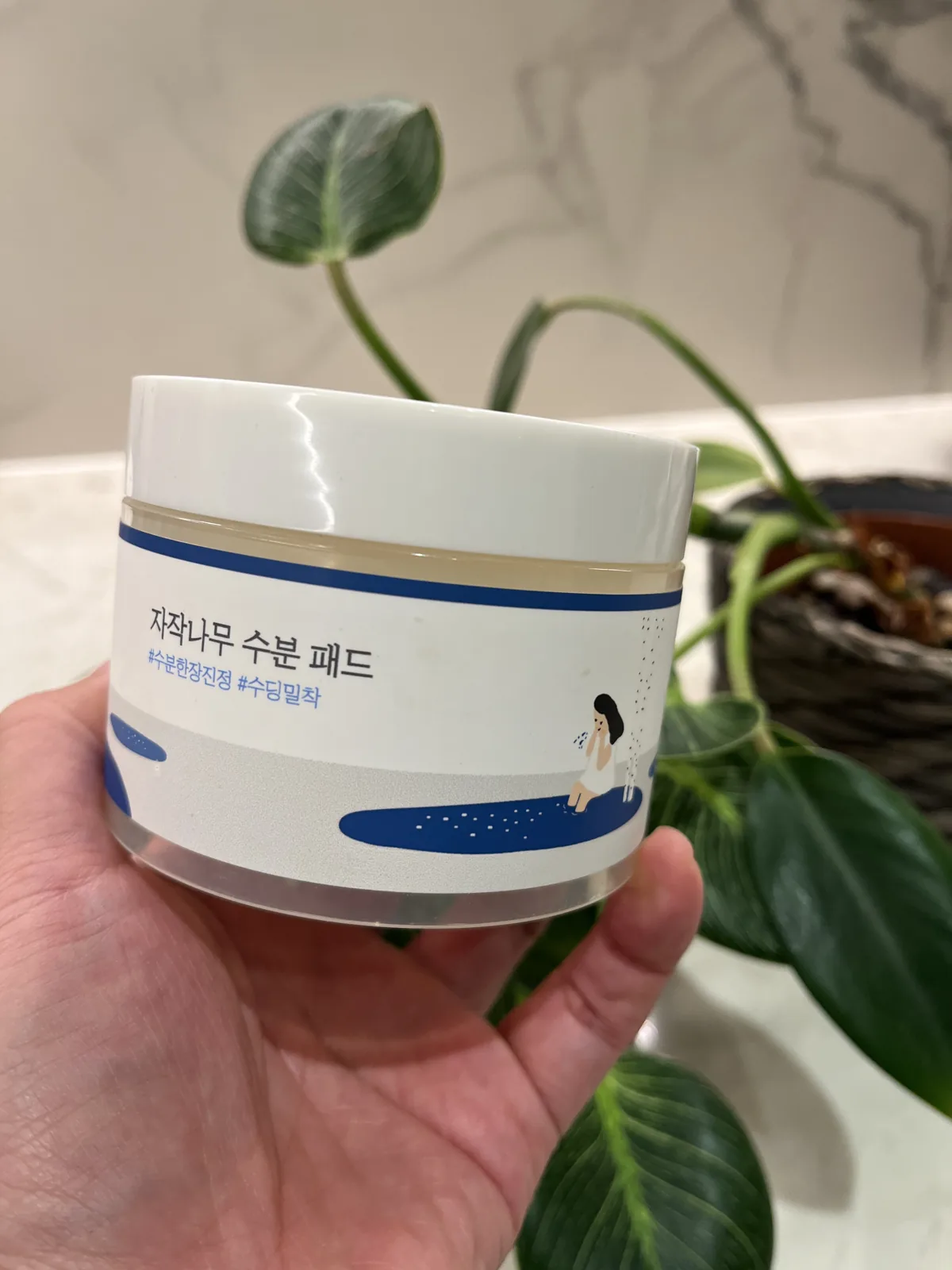 Round Lab birch moisture toner pad jar held in hand — best Korean toner pads that actually work
