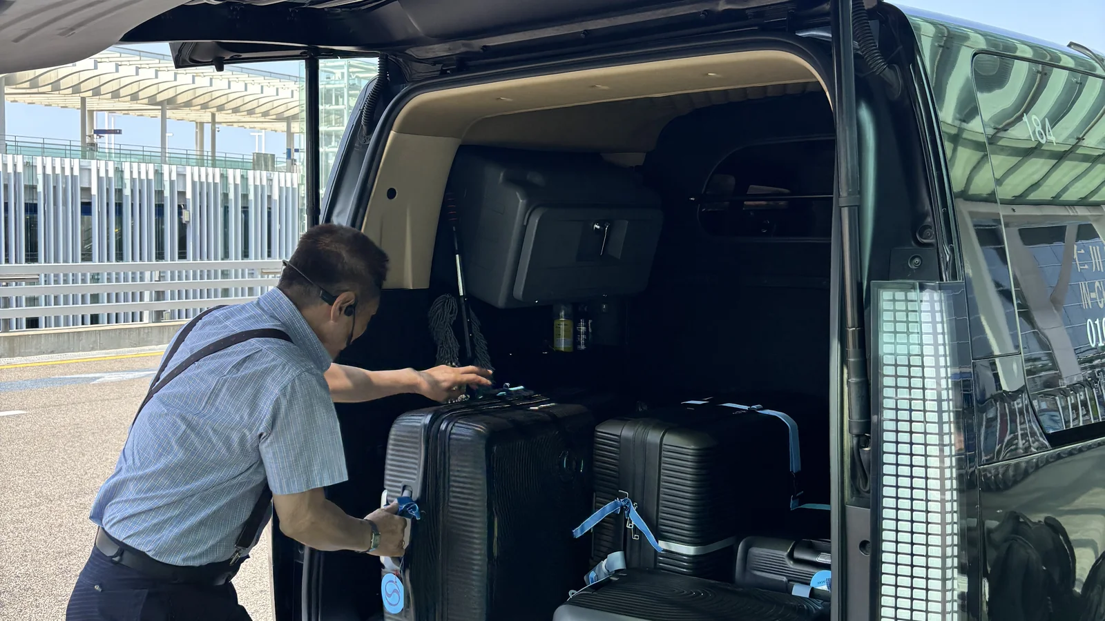 Driver loading luggage into a private airport transfer van at Incheon Airport