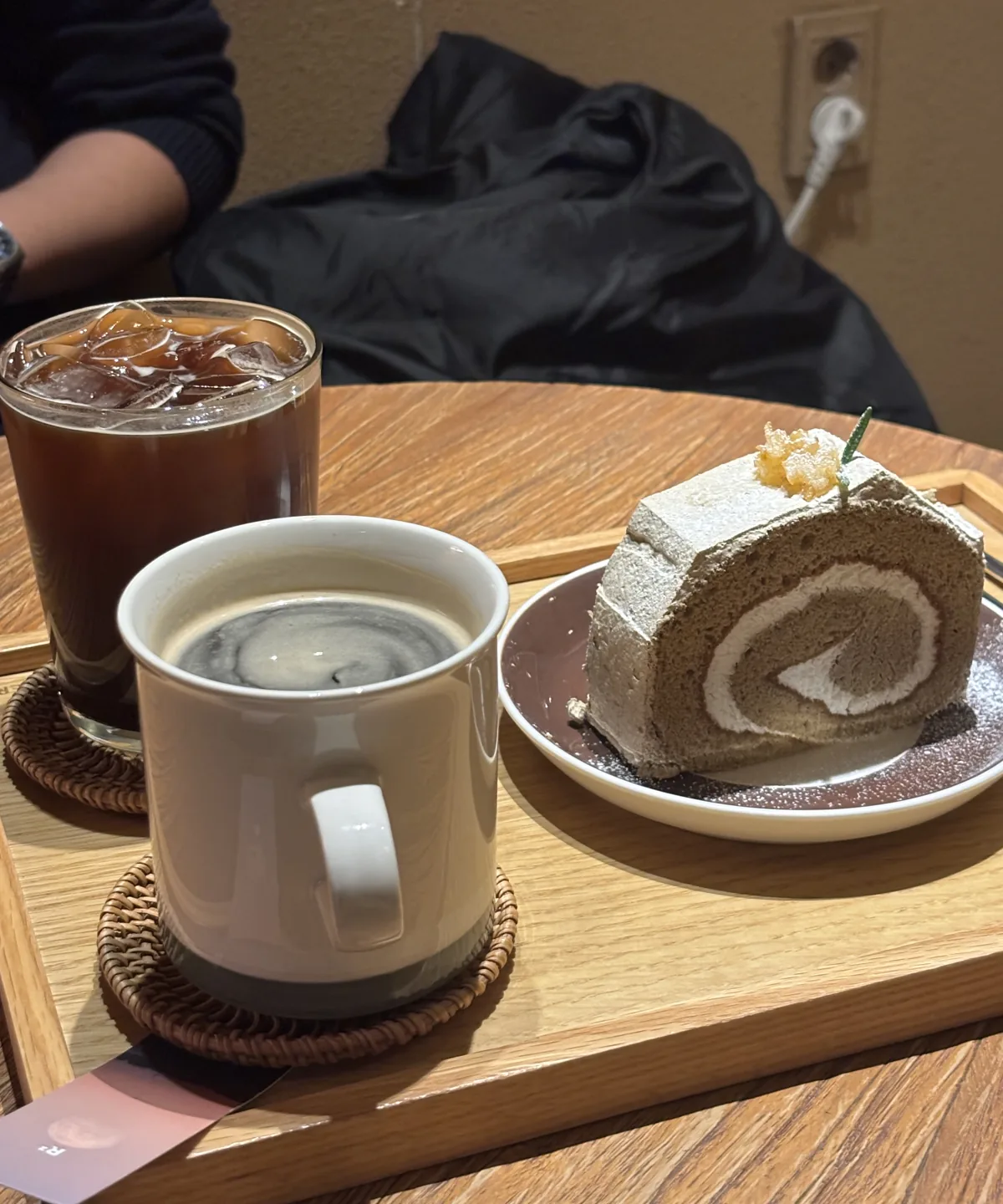 best cafes in Seongsu-dong: a hojicha roll cake with black coffee and iced americano on a wooden tray at a Seongsu cafe
