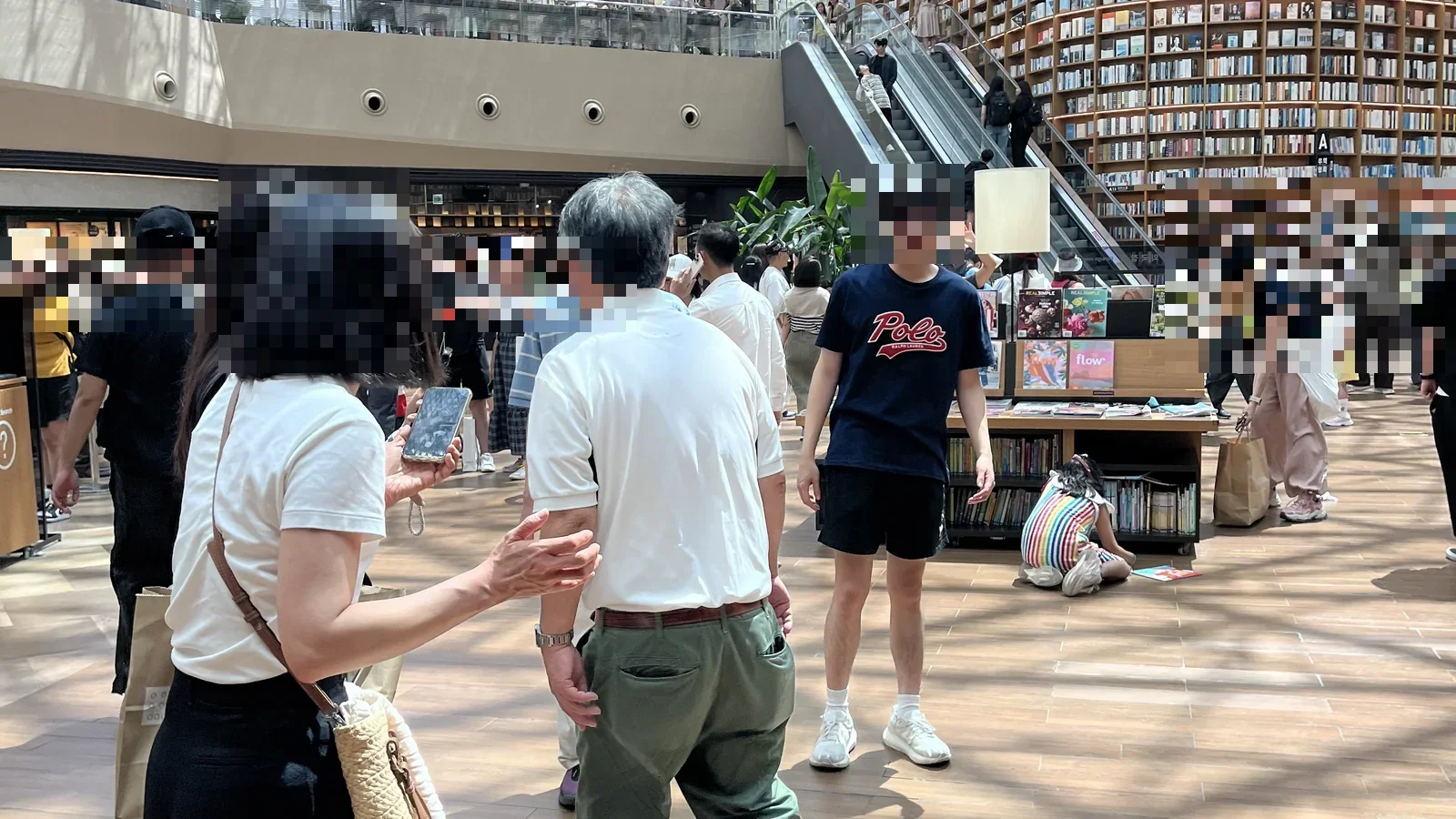 Visitors gathered near the Starfield Library bookshelves and escalator at COEX Mall, Gangnam
