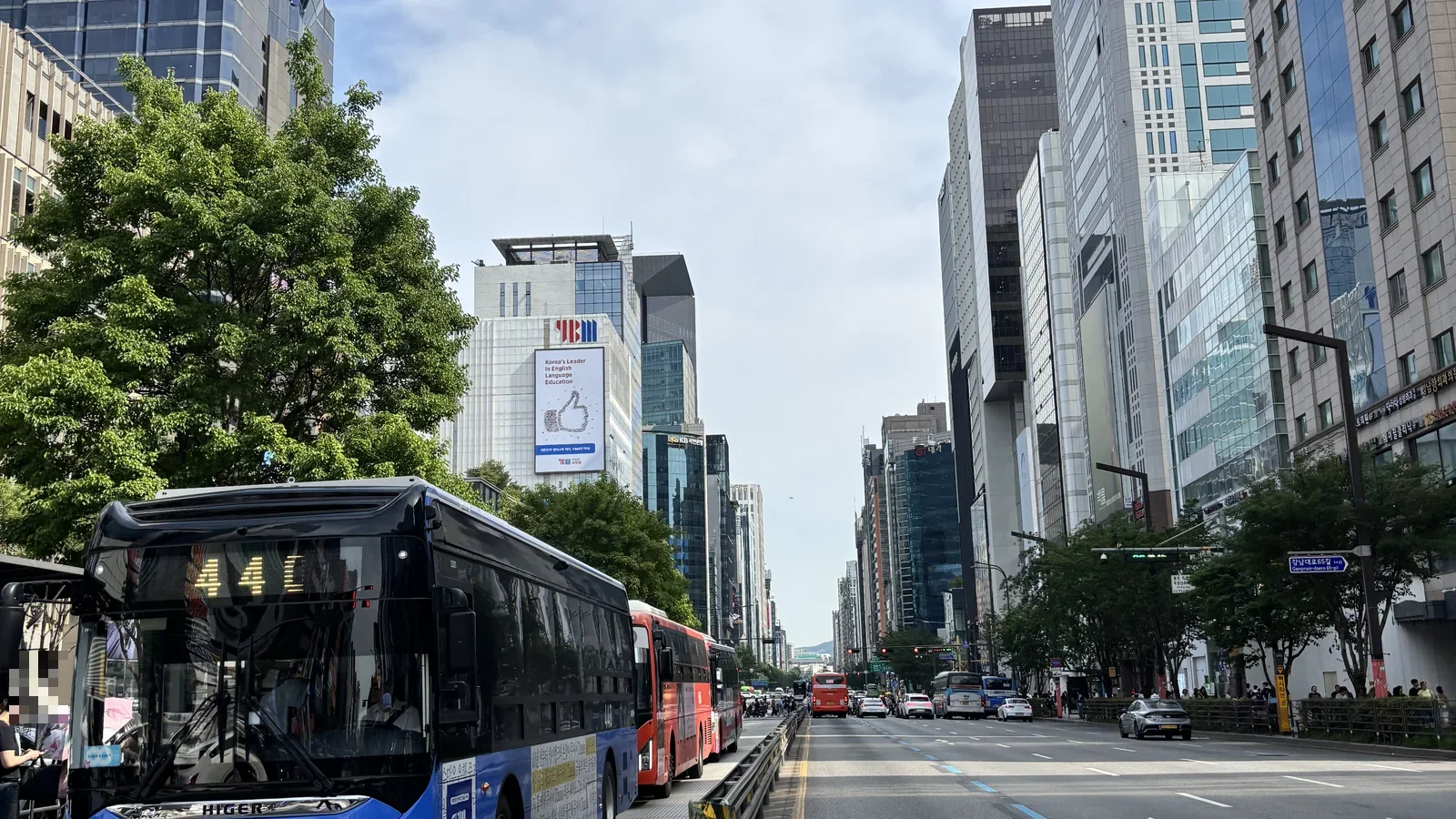 Gangnam-daero boulevard near Gangnam Station, Seoul, lined with glass office towers and city buses