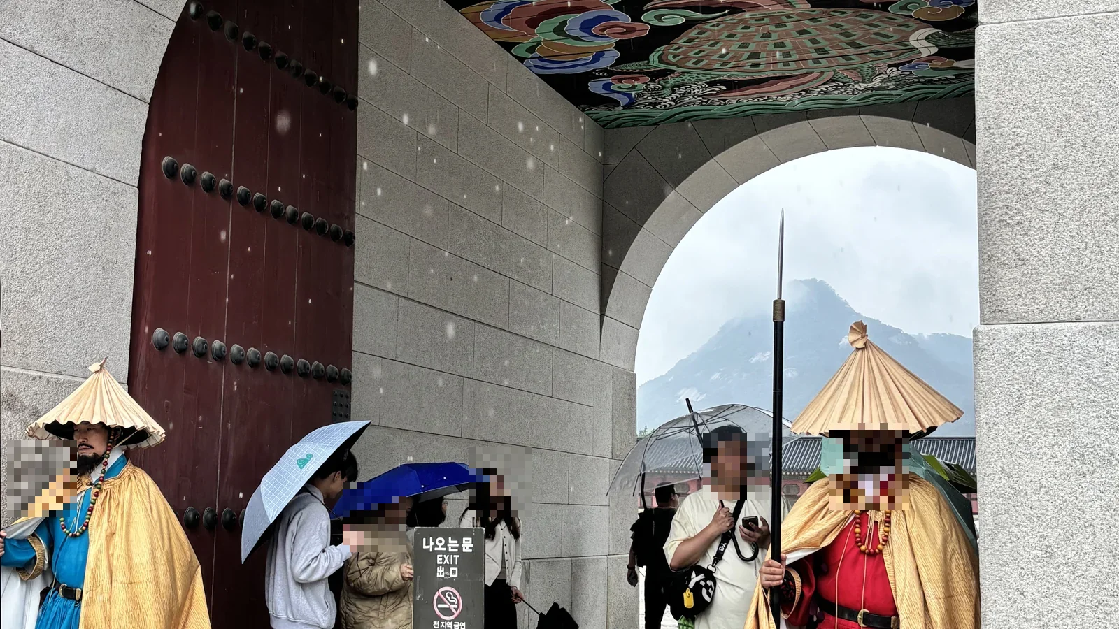 Royal guards in traditional dress at Gwanghwamun Gate, Gyeongbokgung Palace, Seoul, on a rainy day