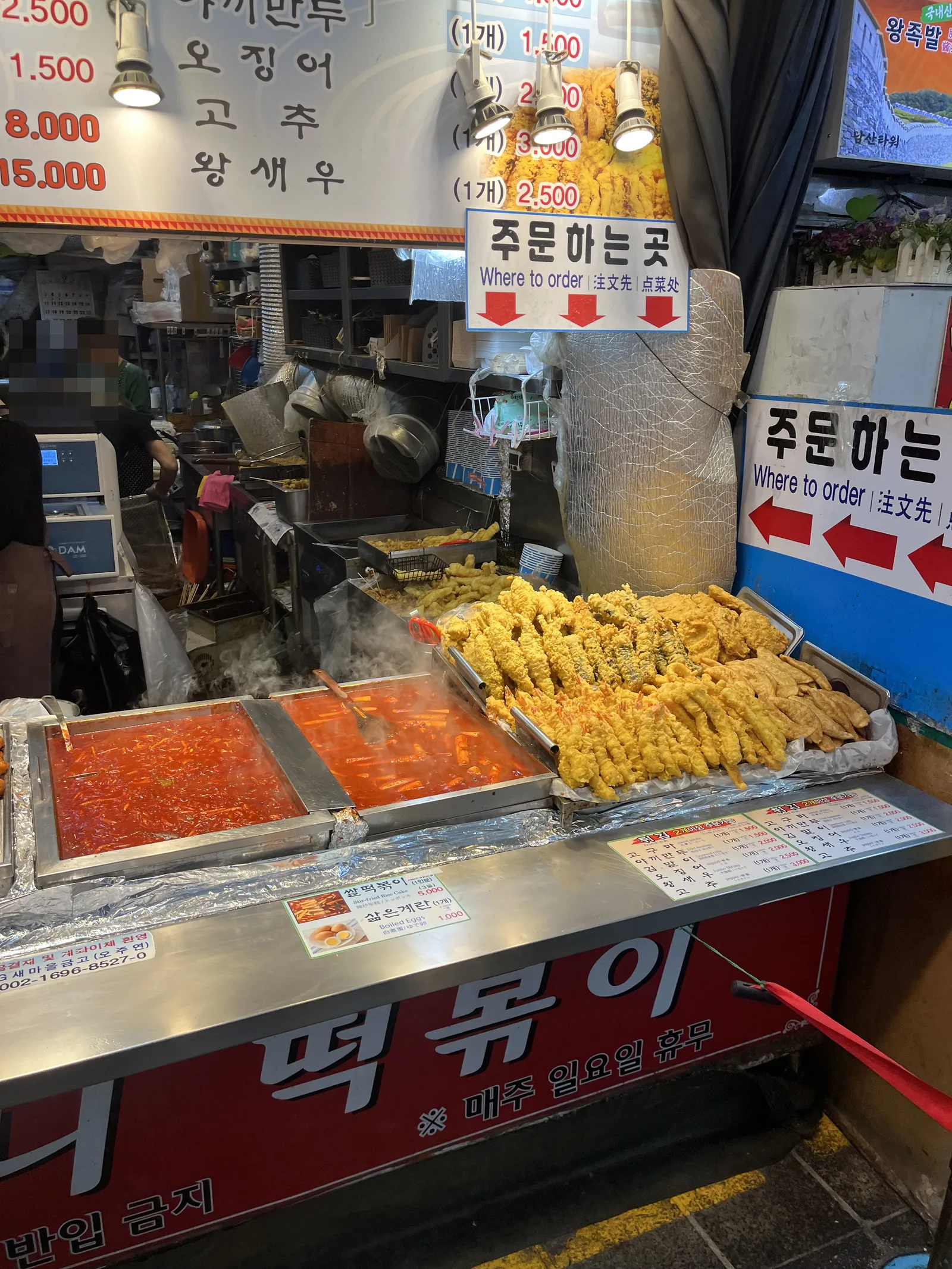 Namdaemun Market street food shown by tteokbokki in red pans beside golden twigim