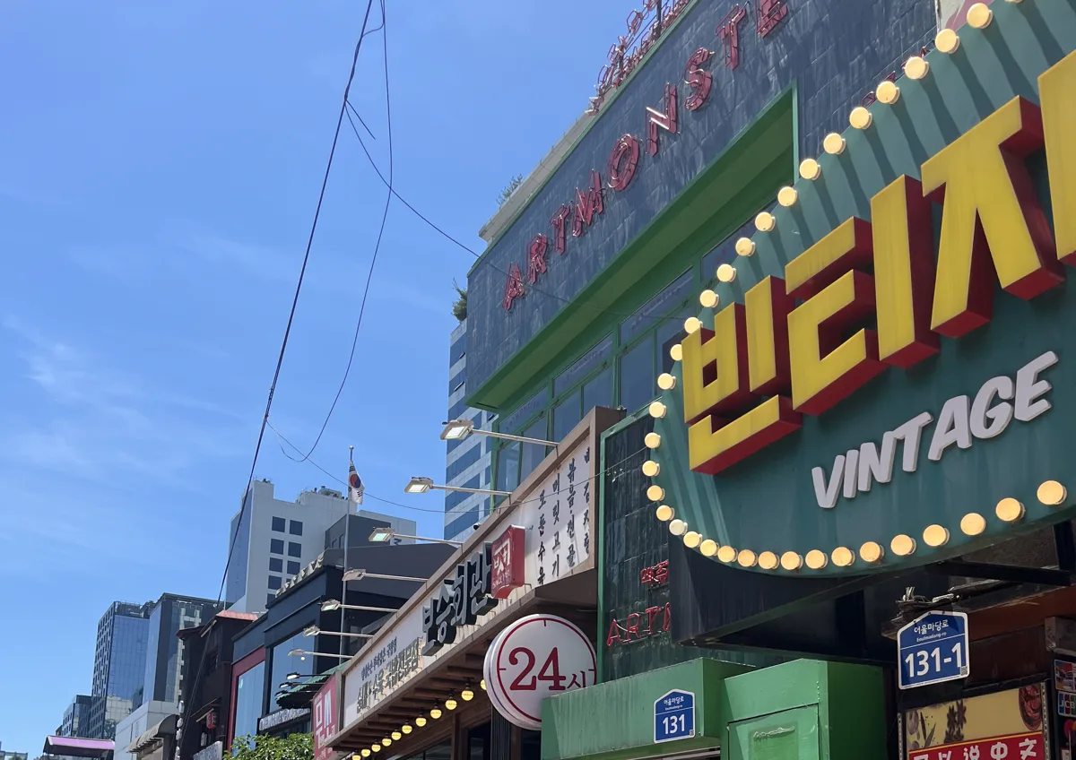 vintage shopping in Hongdae Seoul: the neon VINTAGE store sign on a Hongdae backstreet