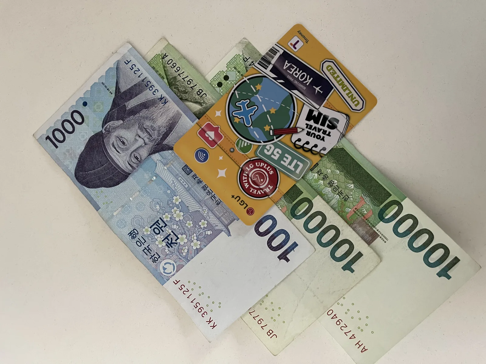 Korea travel budget 2025: Korean won banknotes with a transit card and travel SIM