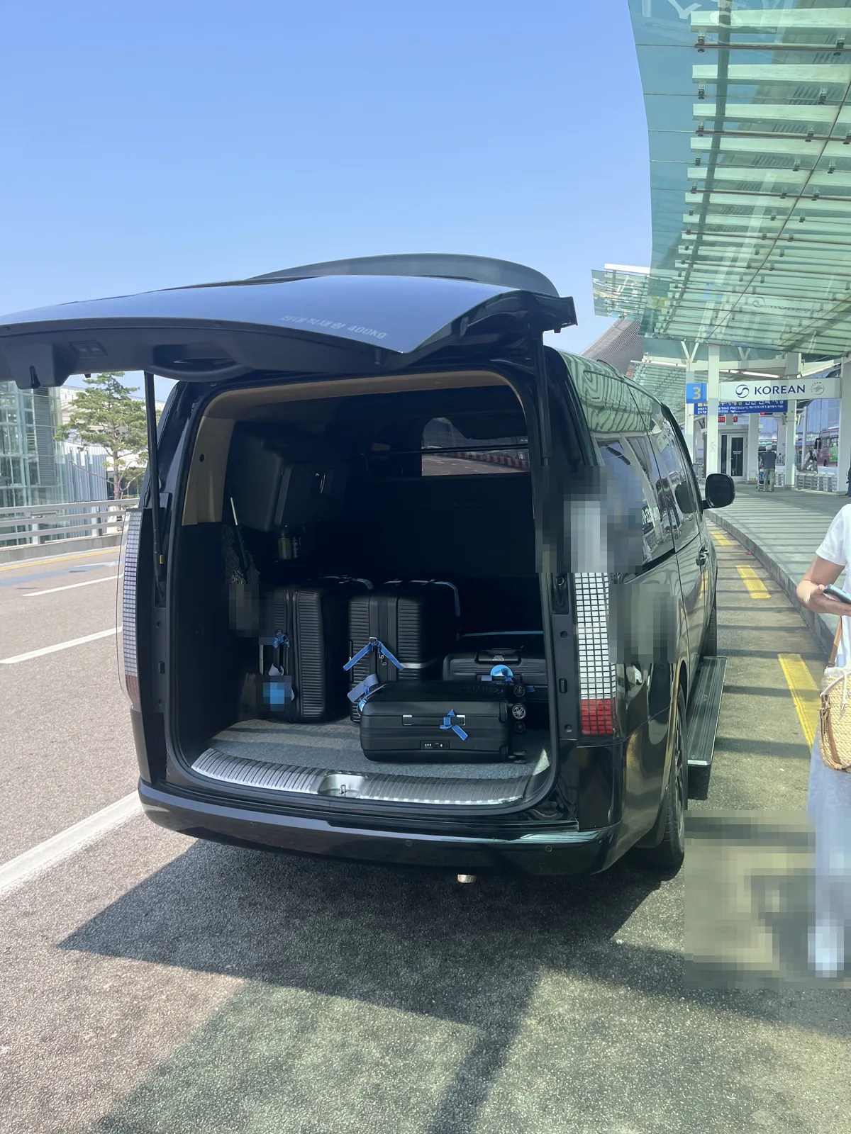 Taxis in Korea alternative: a van transfer loading luggage at Incheon Airport kerb
