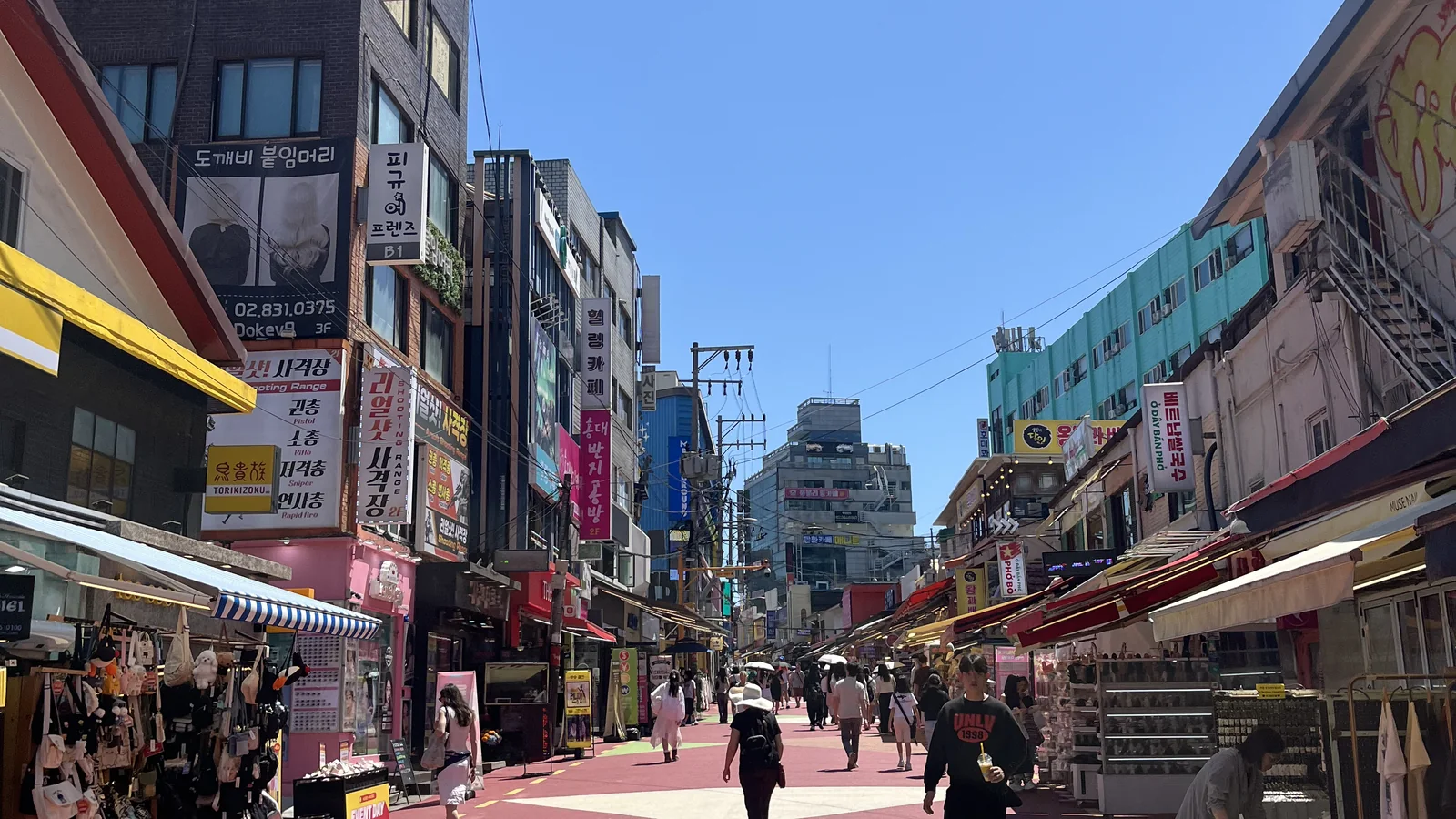 Hongdae walking street in daylight with shops and signs on both sides — Hongdae Seoul travel guide